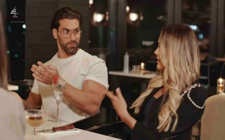 a man and a woman are sitting at a table in a restaurant talking to each other .