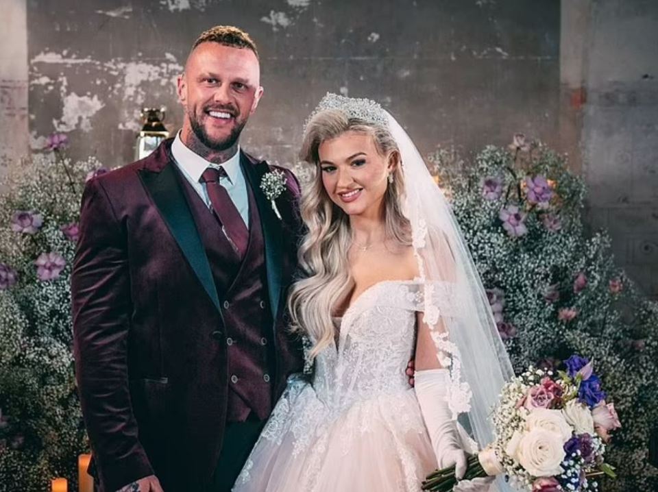 a bride and groom pose for a picture in front of flowers