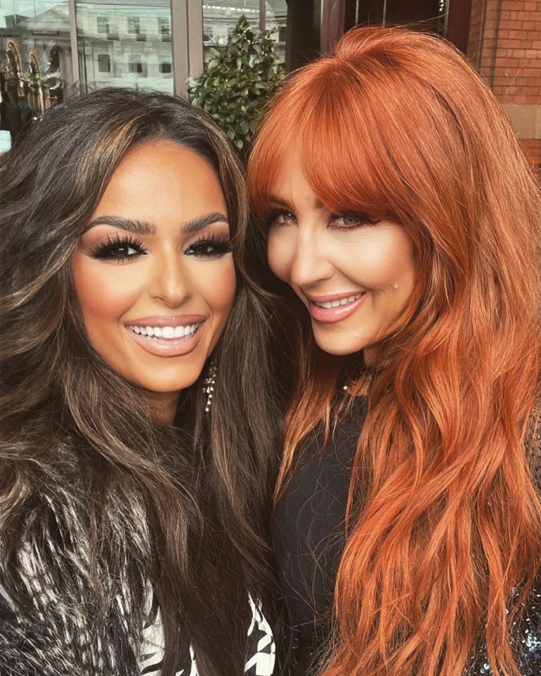 two women are posing for a picture and one has red hair