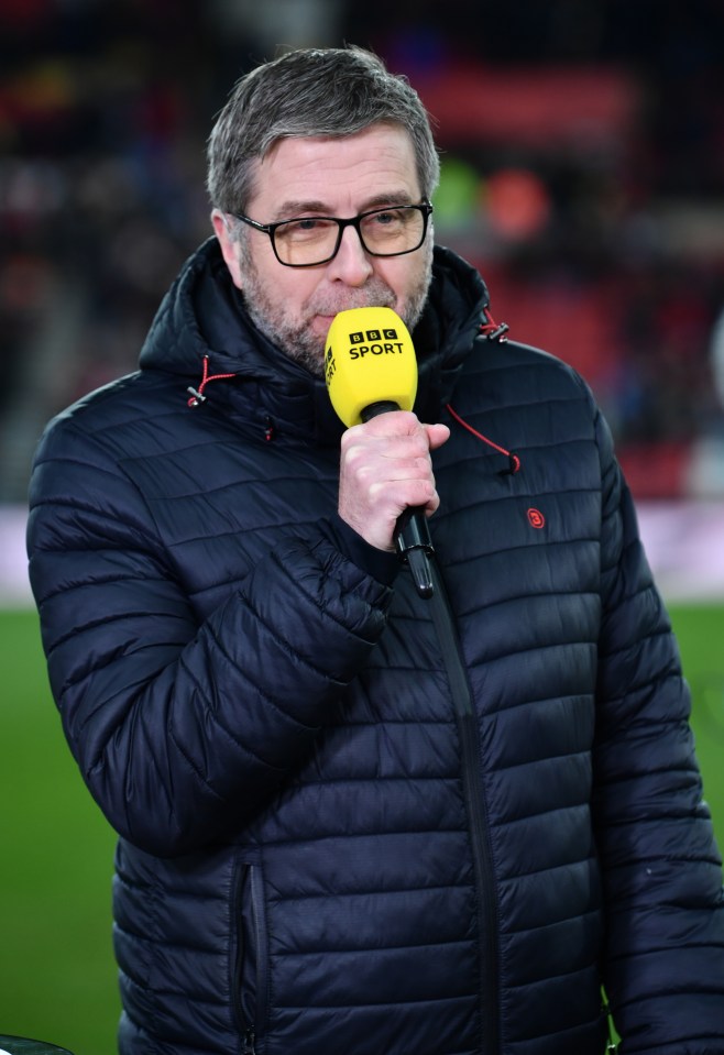 a man in a bbc sport jacket holds a yellow microphone