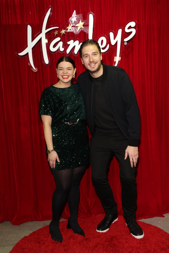 a man and a woman pose in front of a harleys sign