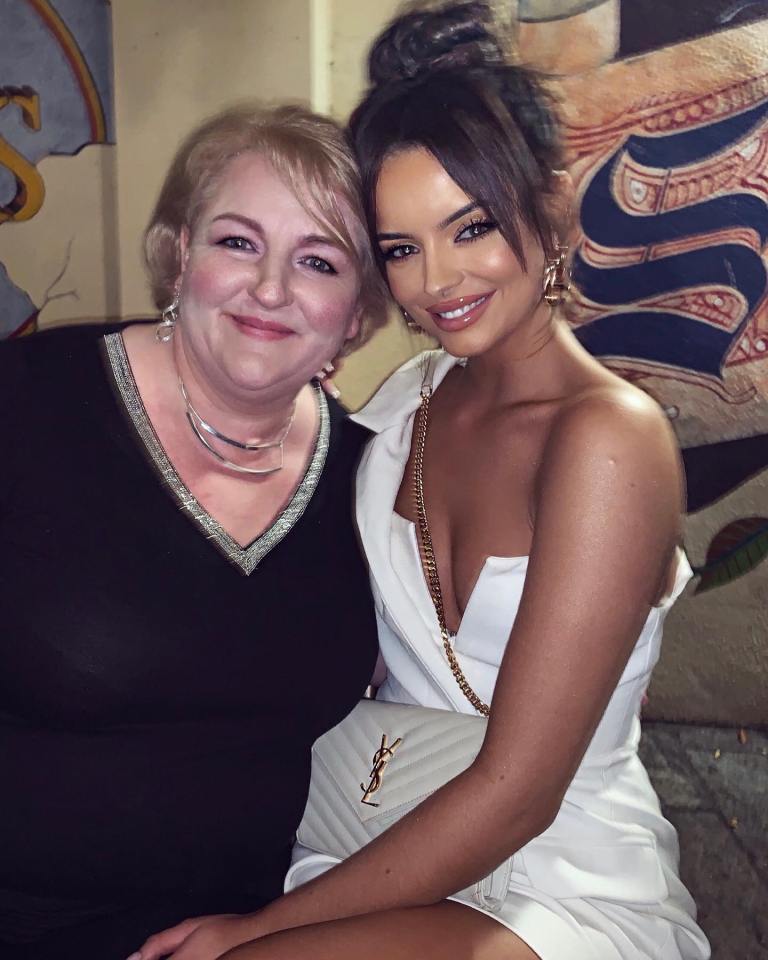 two women posing for a picture with one wearing a yves saint laurent purse