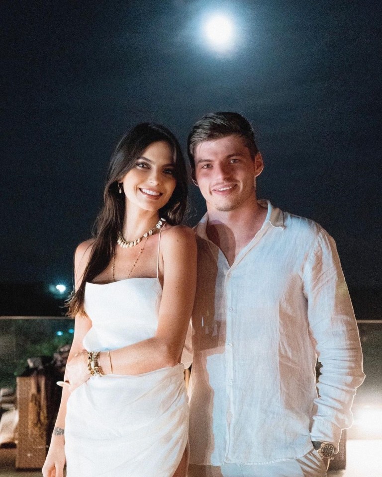 a man and a woman pose for a picture in front of a full moon