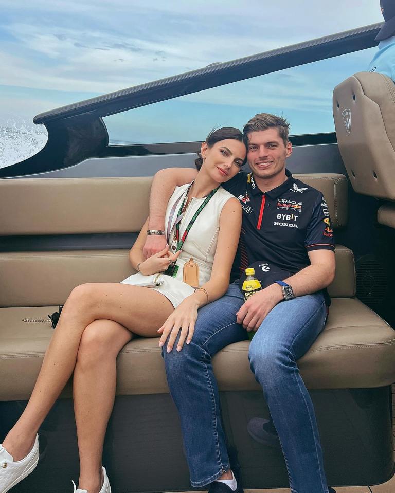 a man in a red bull shirt sits next to a woman on a boat