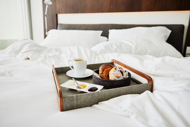 a bed with a tray of food and a cup of coffee