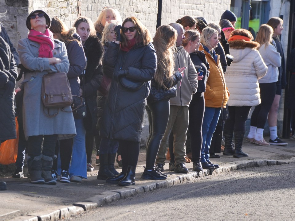 Members of the public line the route to the funeral service