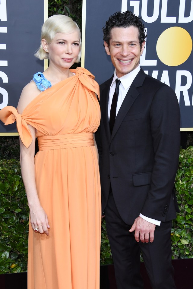 a man and a woman are posing for a picture on a red carpet that says gold star