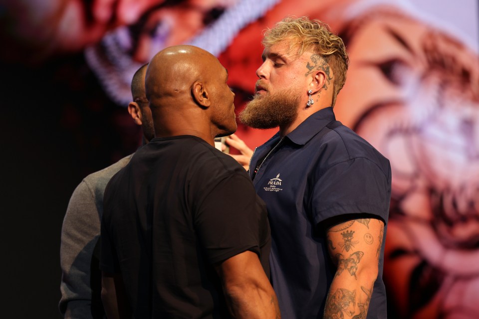 a man wearing a palm shirt stands next to another man