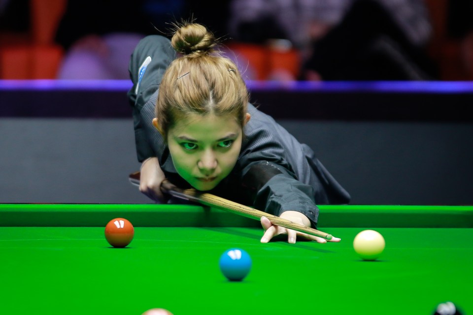 a woman playing snooker with the number 11 on the table