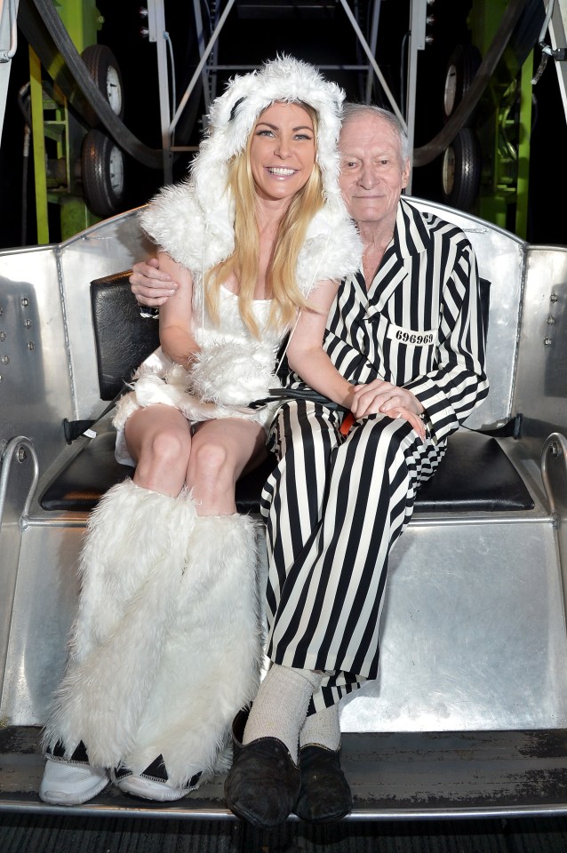 a man and a woman are sitting on a chair with the man wearing a striped robe that says 000000