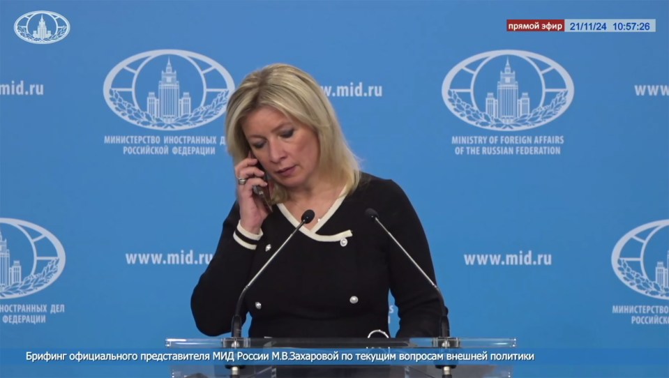 a woman speaks into a microphone in front of a wall that says ministry of foreign affairs of the russian federation