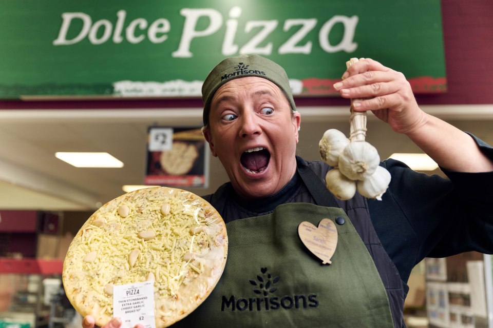 a woman holding a pizza in front of a sign that says dolce pizza