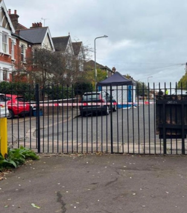 a car is parked in a parking lot behind a fence that says ' ambulance ' on it