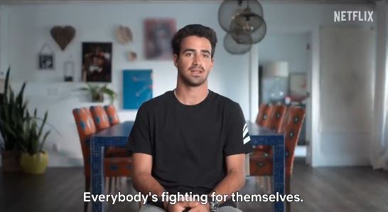 a man is sitting at a table in a living room talking about fighting for themselves .