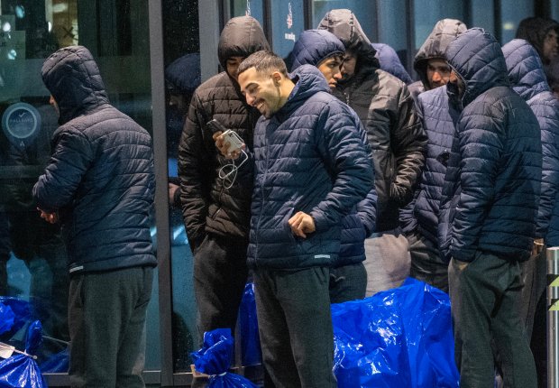 a man in a blue jacket looks at his phone