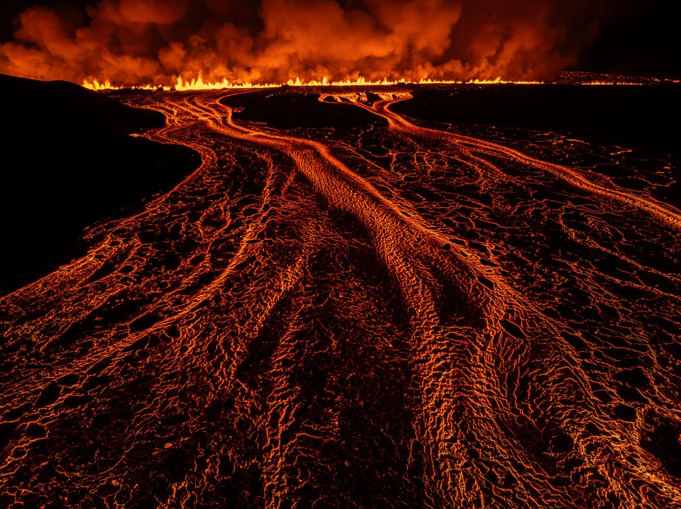 a large amount of lava is coming out of a volcano