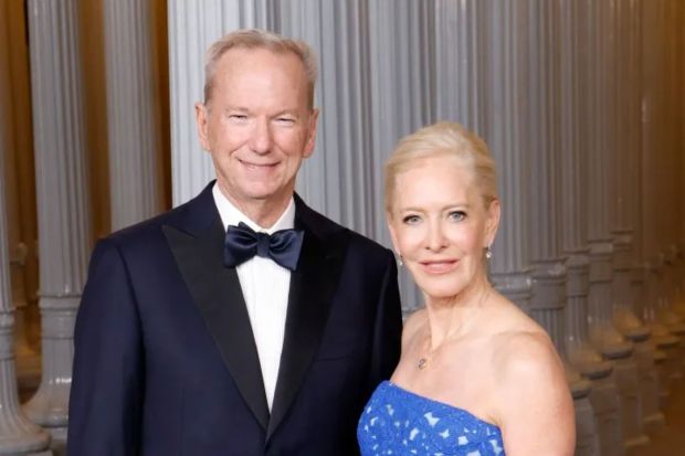 a man in a tuxedo and a woman in a blue dress pose for a picture