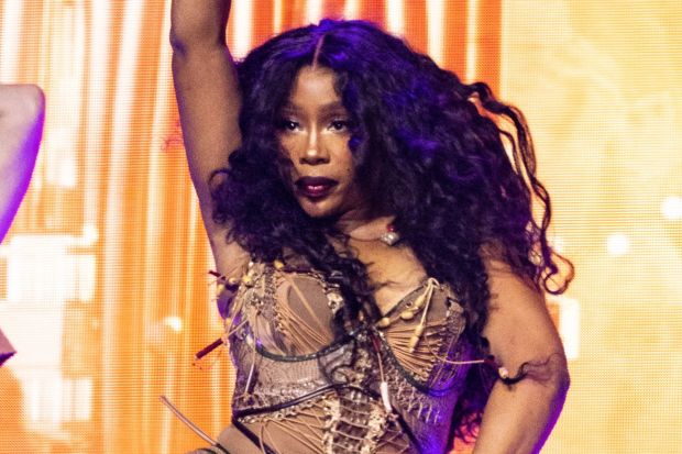 a woman with long curly hair is dancing on a stage