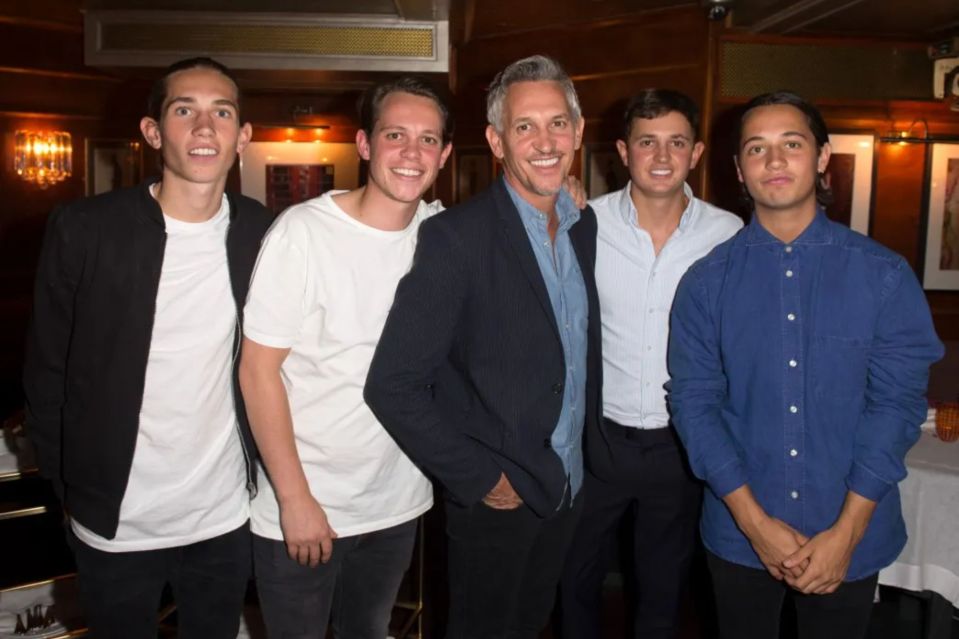 a group of men posing for a picture with one wearing a blue shirt