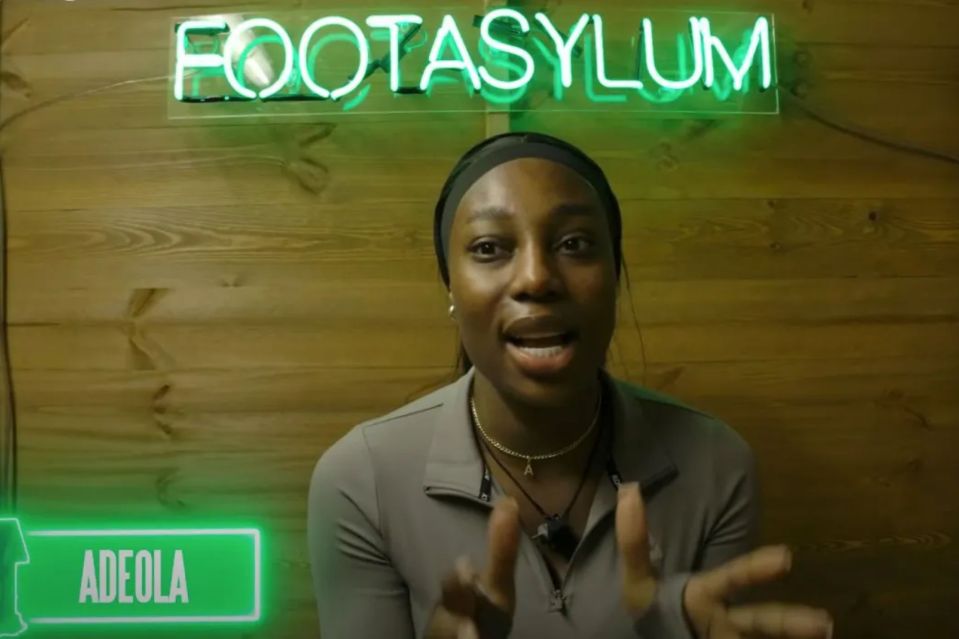 a woman stands in front of a neon sign that says footasylum