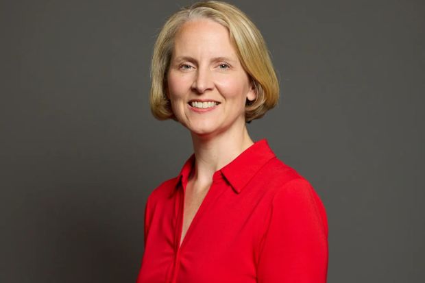 a woman in a red shirt smiles for the camera