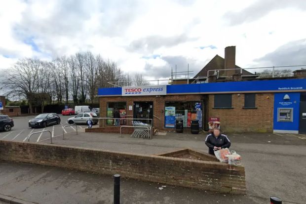 a tesco express store with cars parked in front of it