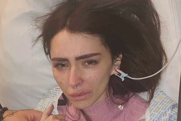 a woman is crying in a hospital bed with an iv in her ear