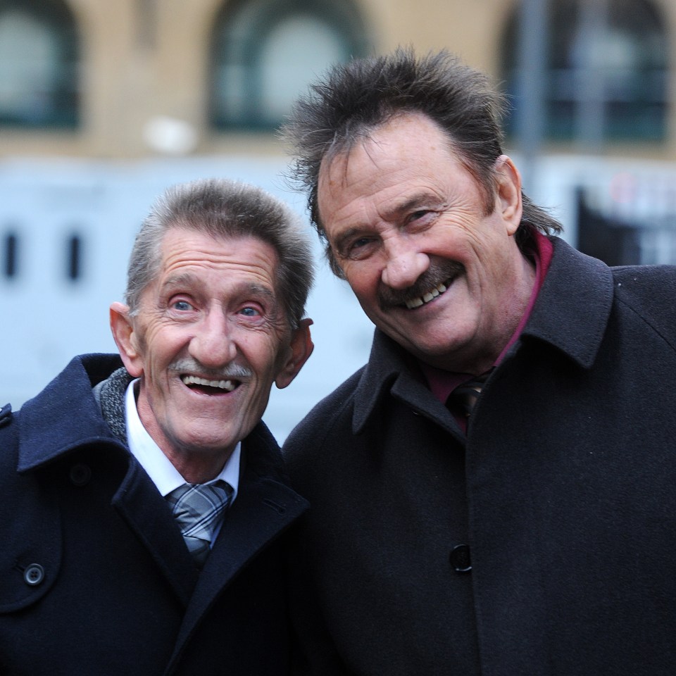 two men are posing for a picture and smiling for the camera