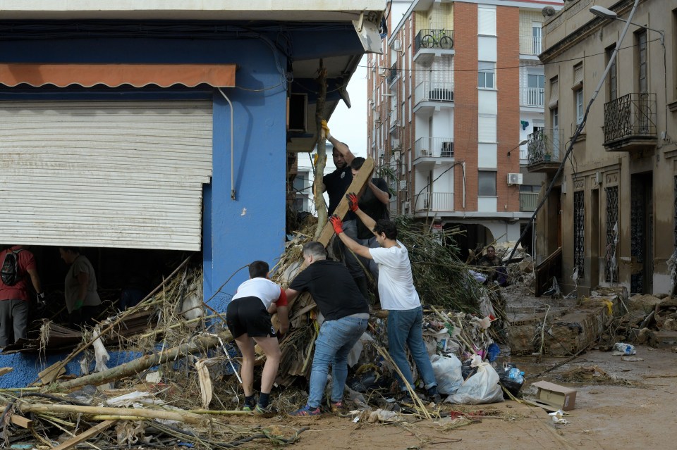 a group of people standing in front of a blue building