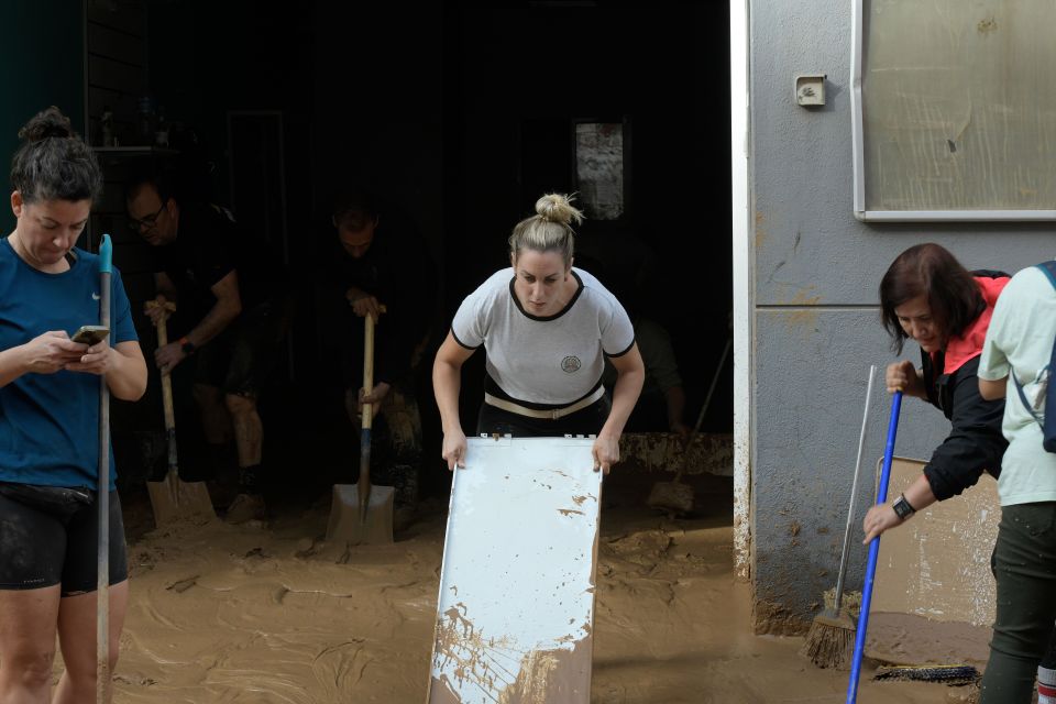 a woman is holding a white board in a flooded area