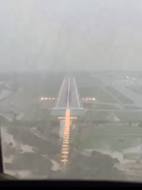 The video shows heavy rain as the runway is barely visible