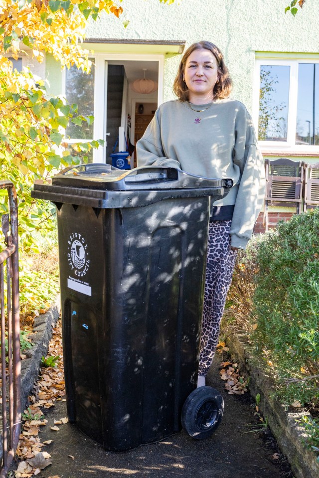 a woman standing next to a bin that says bristol council