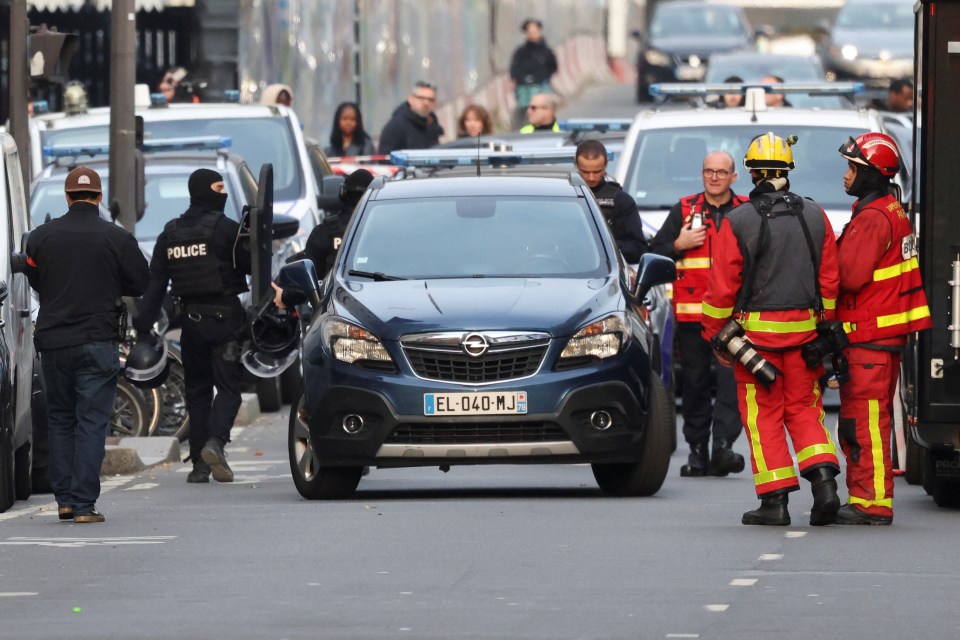 Police members and firefighters work outside the pizza restaurant