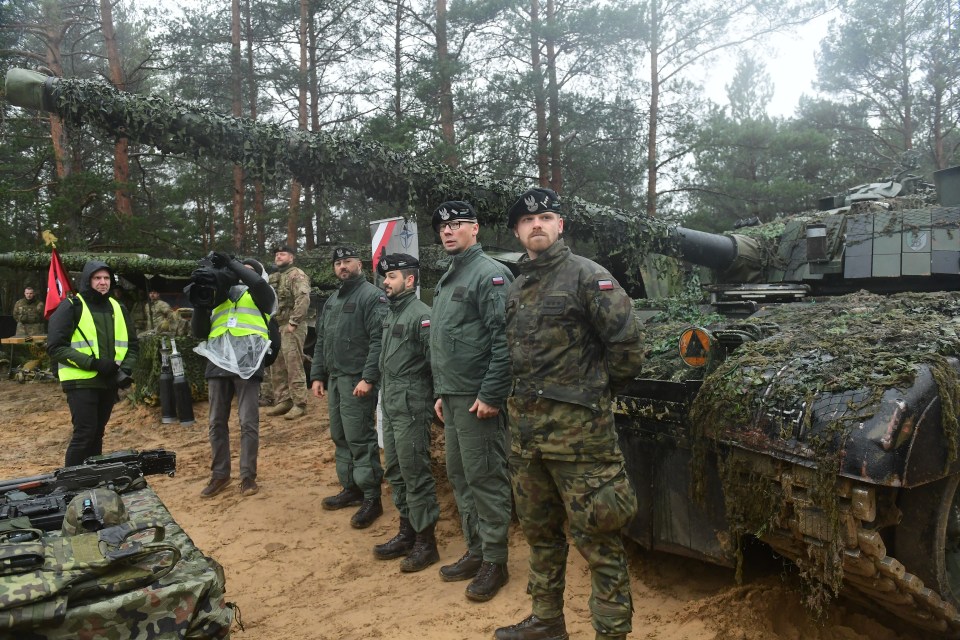 Polish soldiers stand in front of their tanks during a visit of Latvia’s President and the NATO Secretary General