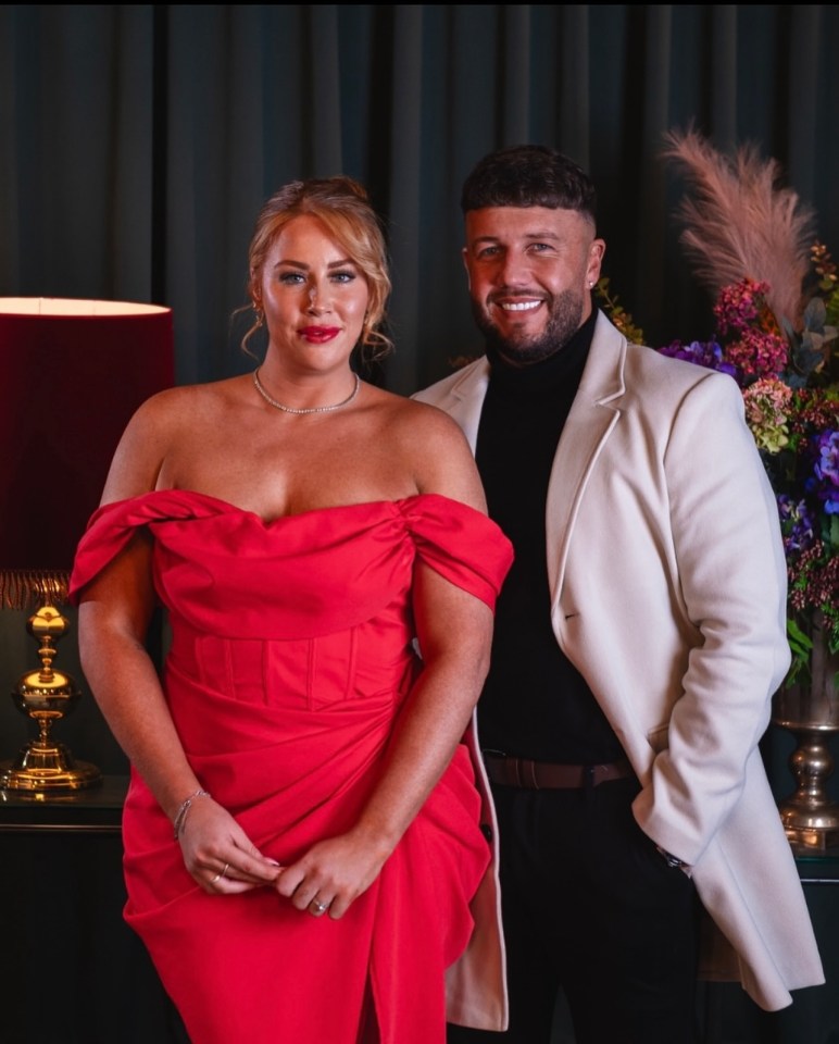 a woman in a red dress stands next to a man in a white coat