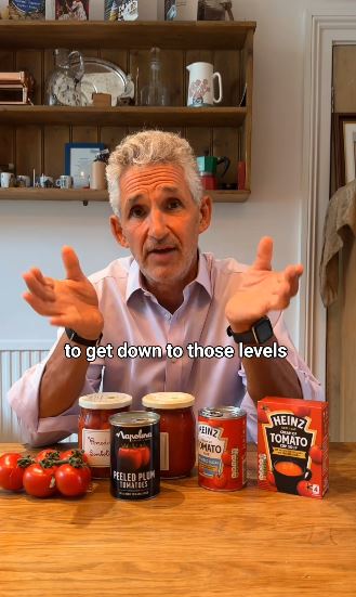 a man is sitting at a table with tomatoes and heinz ketchup .