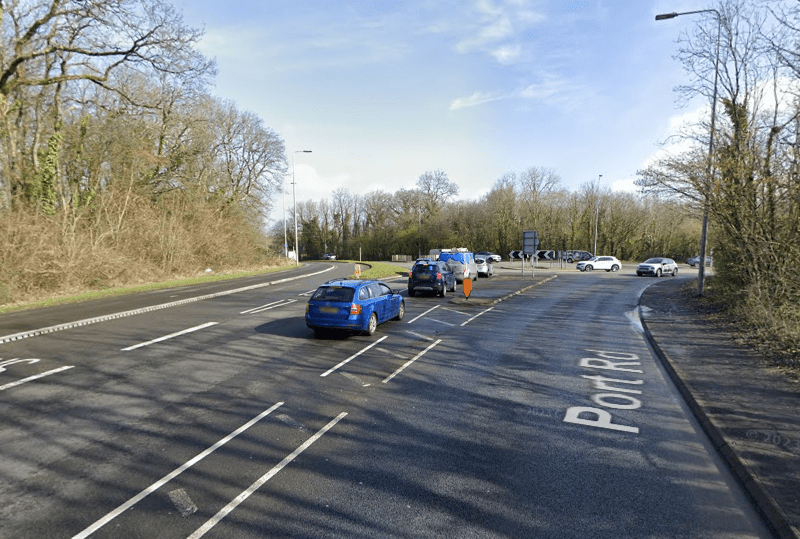 a blue car is driving down port road