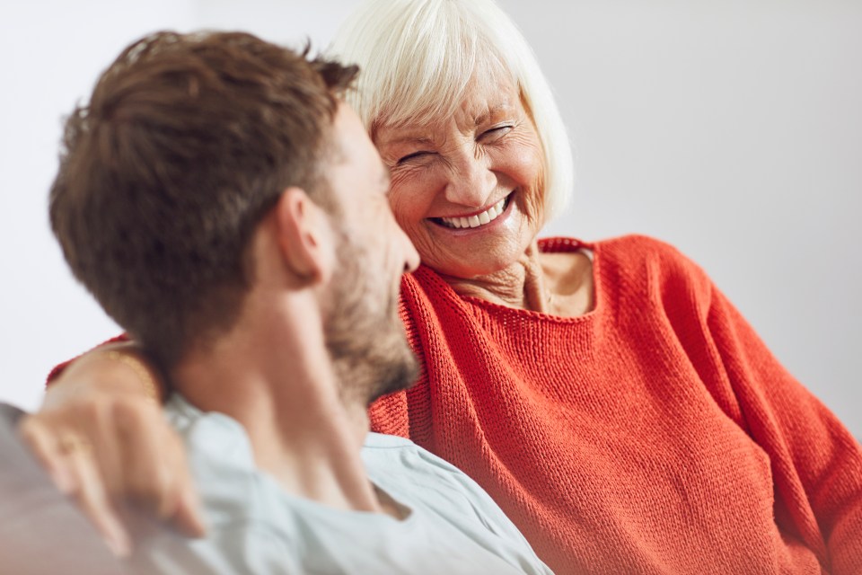 a woman in a red sweater laughs with a man