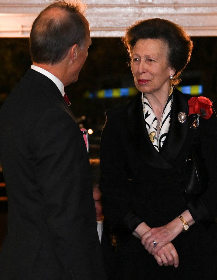 a man in a suit talks to a woman in a black dress