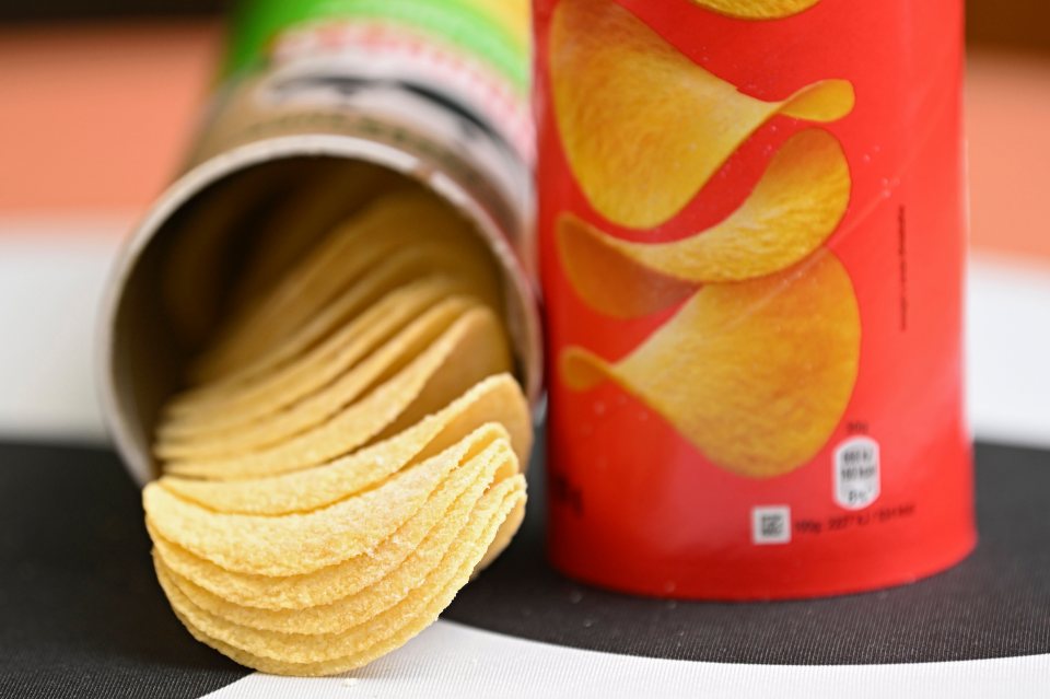 Pringles potato chips spilling from a new recyclable paper tube.