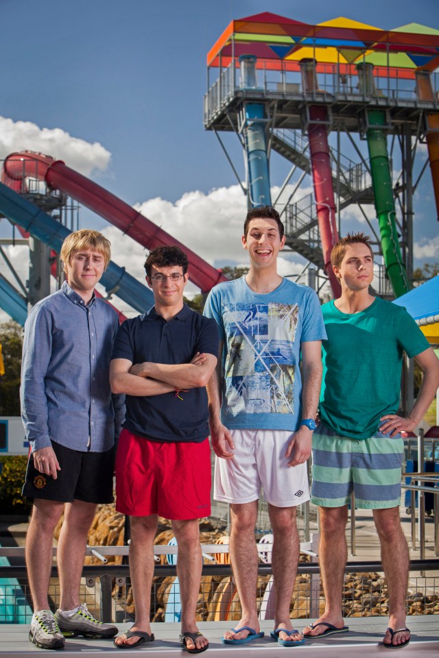 a group of young men standing in front of a water slide