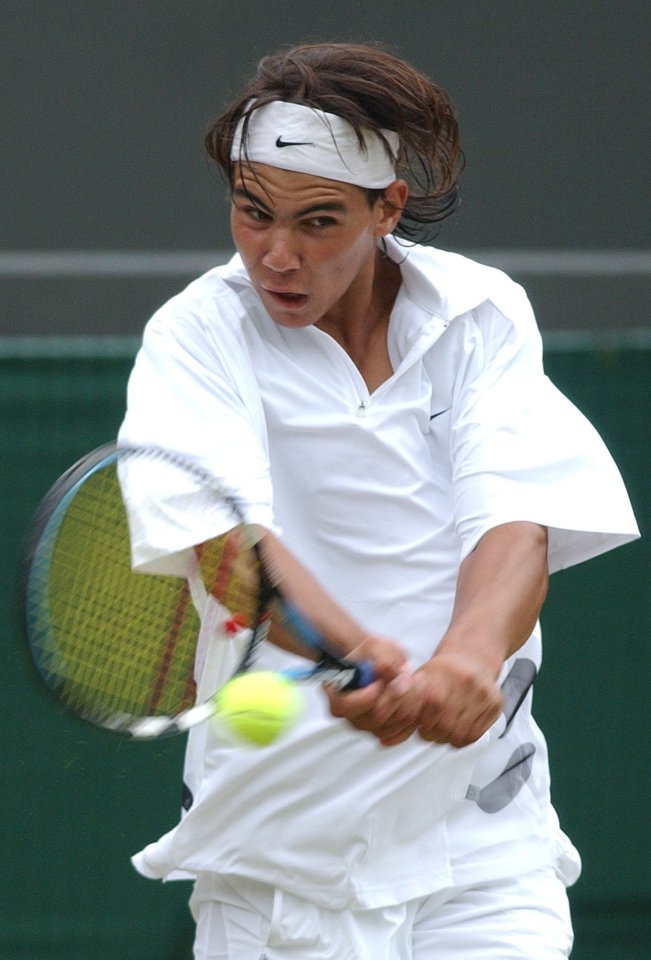 a man wearing a nike headband is playing tennis