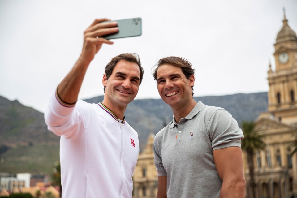 a man taking a selfie with another man in front of a building