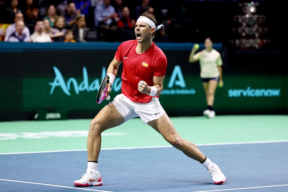 a man in a red shirt is holding a tennis racquet on a tennis court