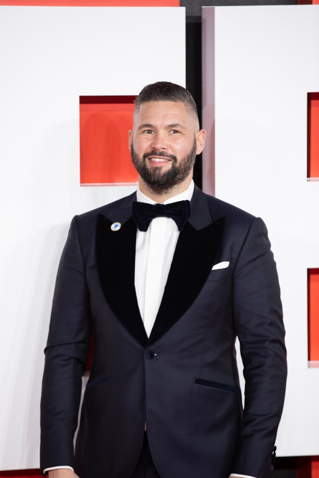 a man in a tuxedo with a badge on his lapel