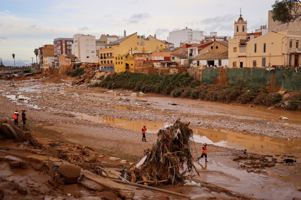 Rescue workers walk, following heavy rains that caused floods, in Paiporta, near Valencia