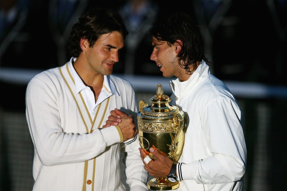 two men shaking hands while one holds a trophy