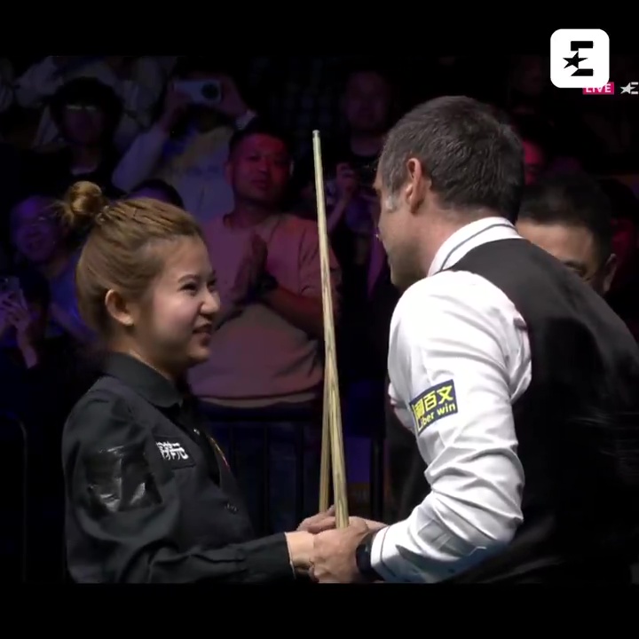 a man and a woman are shaking hands in front of a crowd and the man has a sticker on his arm that says bwin