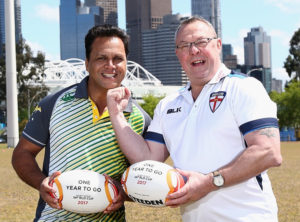 two men holding rugby balls that say one year to go