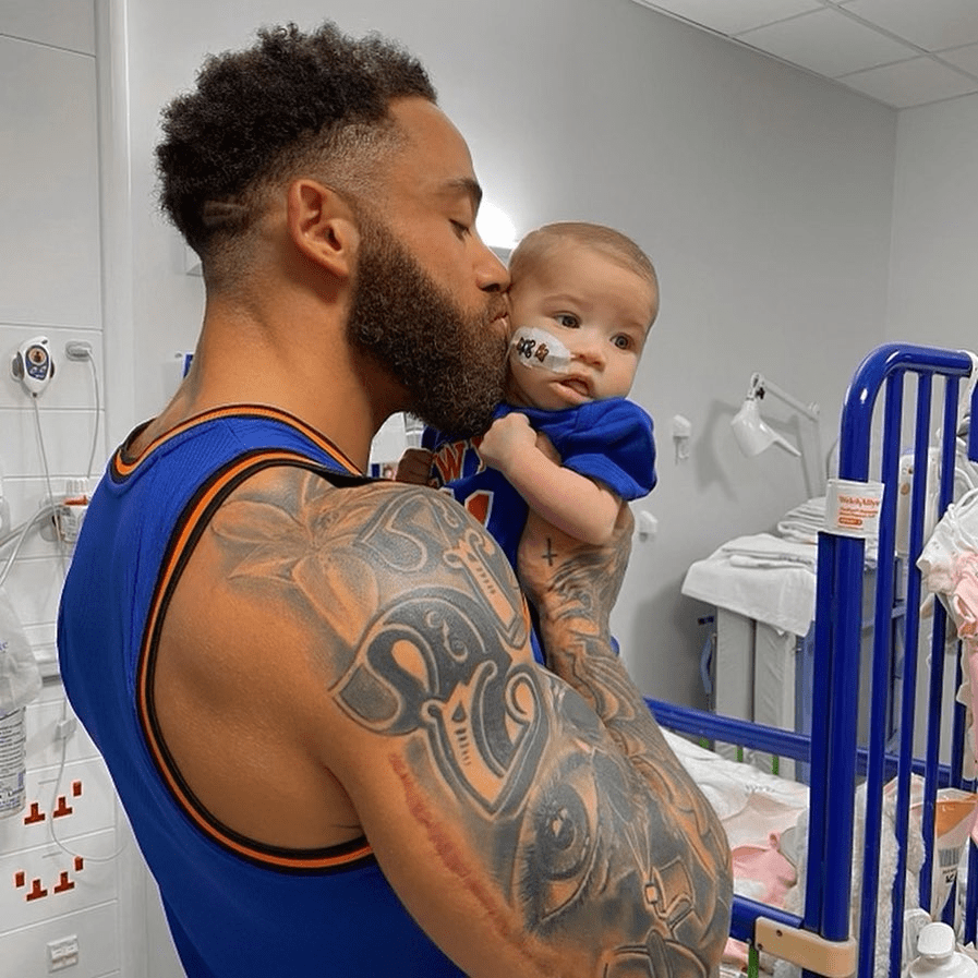 Man kissing baby in hospital.